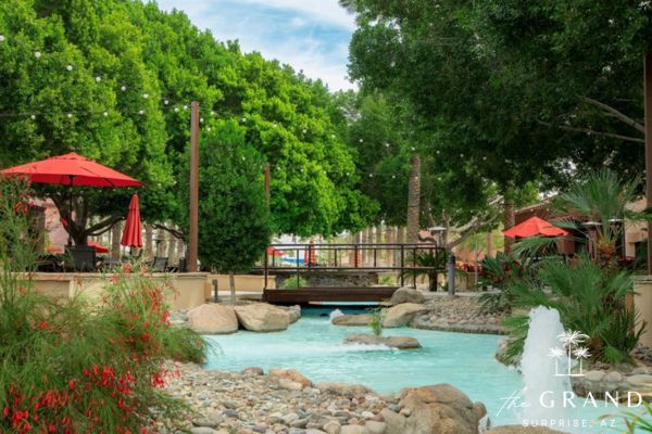 Landscaped water feature, shaded seating and red umbrellas at the Village Center in The Grand, Surprise, Arizona