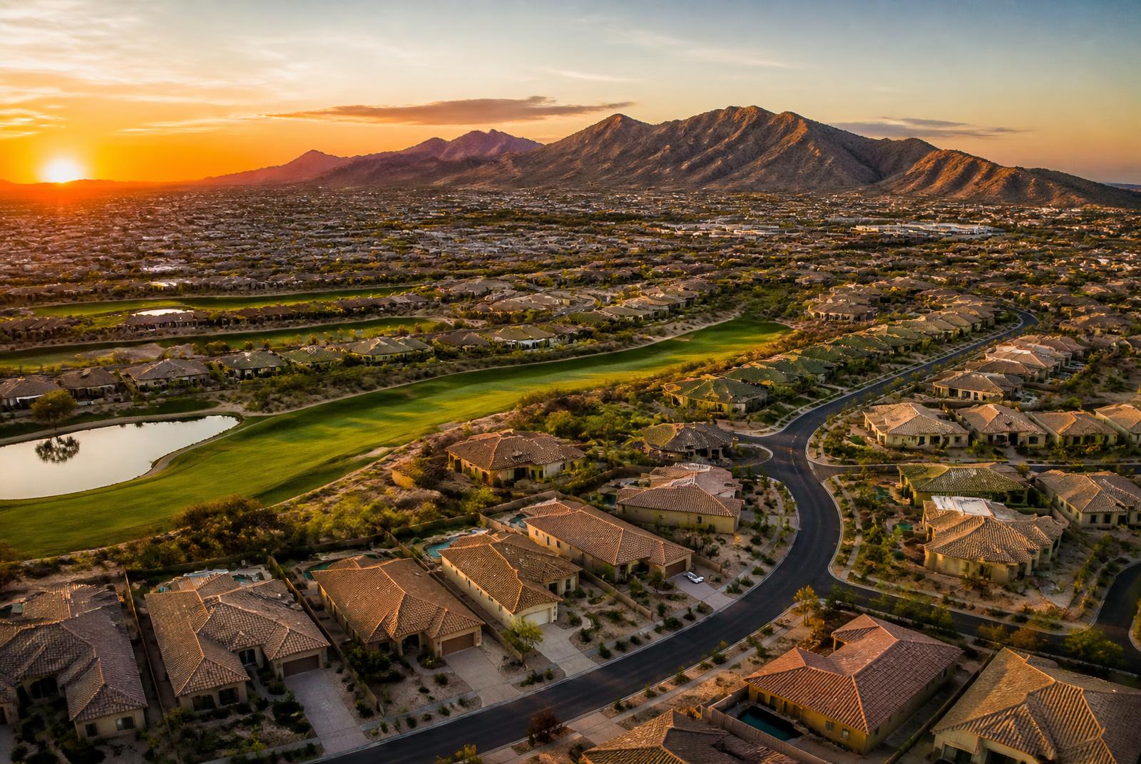 Aerial view at sunset of West Valley Phoenix neighborhoods and golf course fairways